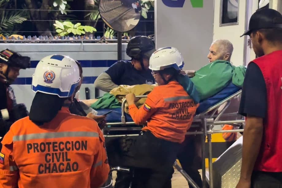 Rescatistas de Protección Civil del Chacao transportan a un rescatado de un edificio.