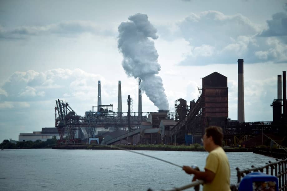 Un hombre pesca en la bahía junto a la planta de carbón DTE en Detroit. Muchas de las personas que viven cerca de la planta sufren de asma. / Ami Vitale, Climate Visuals