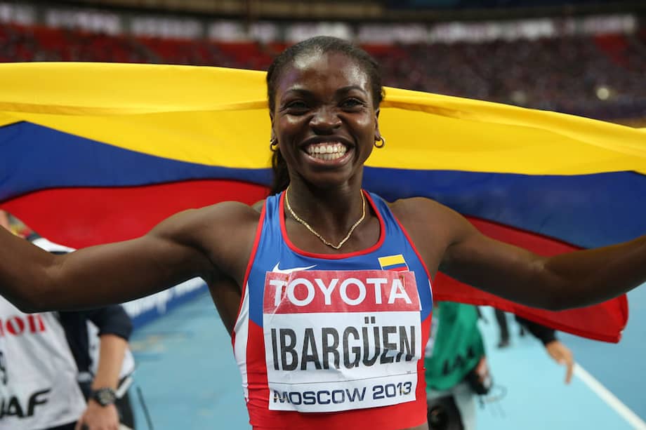 Así, rodeada con el tricolor nacional y con una bella sonrisa, celebró la atleta colombiana Caterine Ibargüen su título mundial en Moscú. / AFP