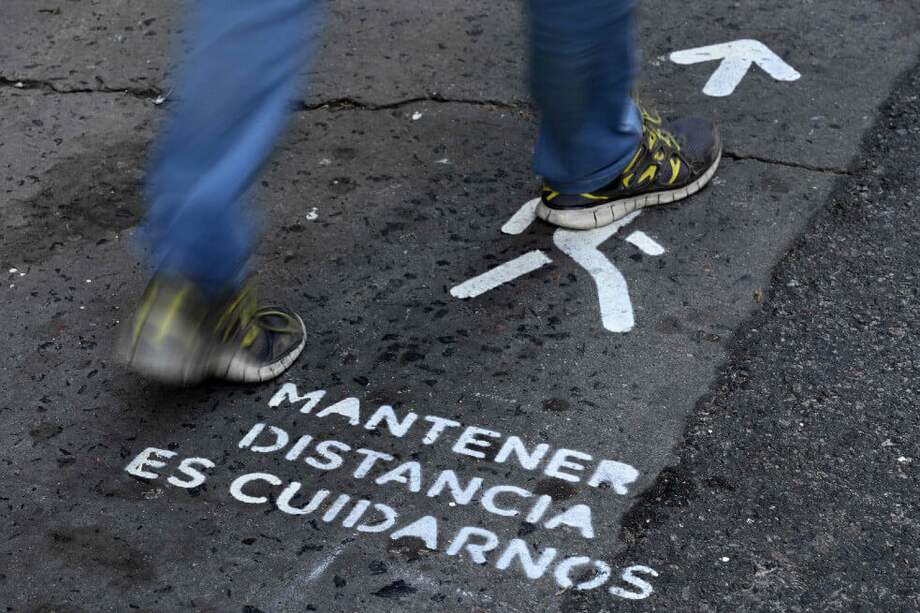 Mensajes de distancia prudencial para los peatones en la Avenida Corrientes de Buenos Aires. / Juan Mabromata / AFP