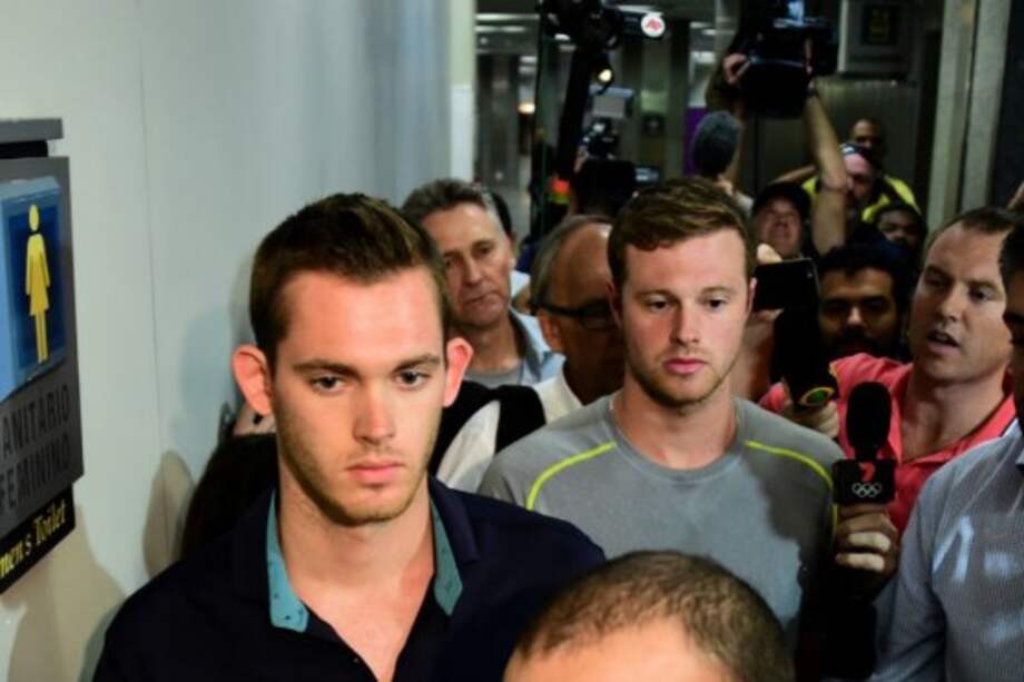 Momento en que dos de los deportistas olímpicos implicados en el supuesto robo salen de declarar en una comisaría de la ciudad. / AFP