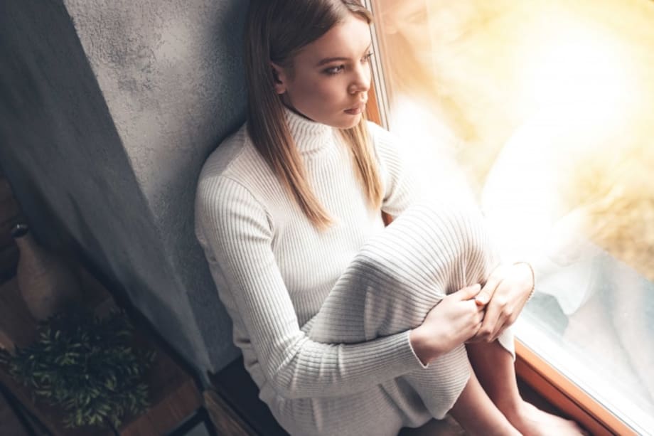 Mujer triste mirando por la ventana