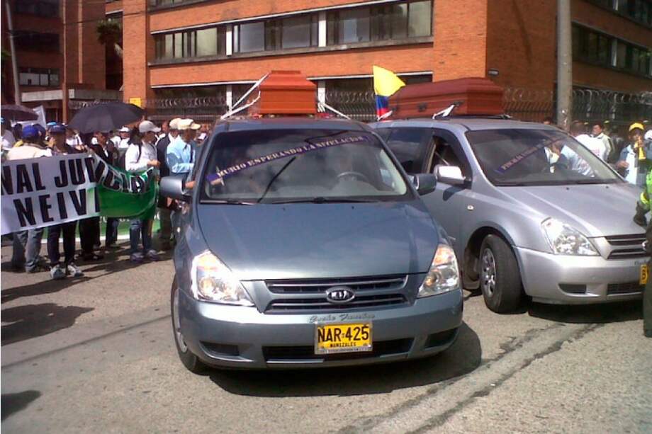 Carros fúnebres que rezan la leyenda "se murió esperando la nivelación salarial".