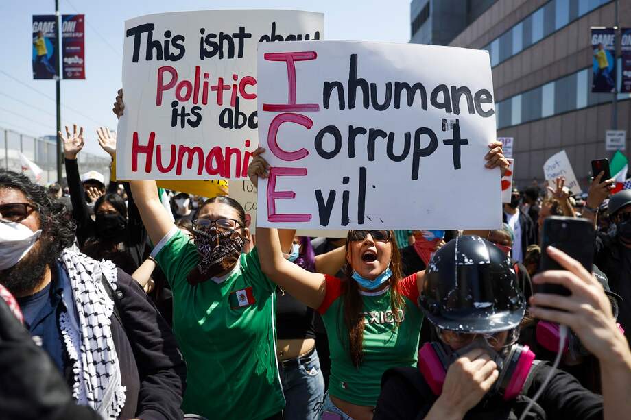 Activistas muestran carteles durante las protestas provocadas por las redadas de inmigración en Los Ángeles, California.