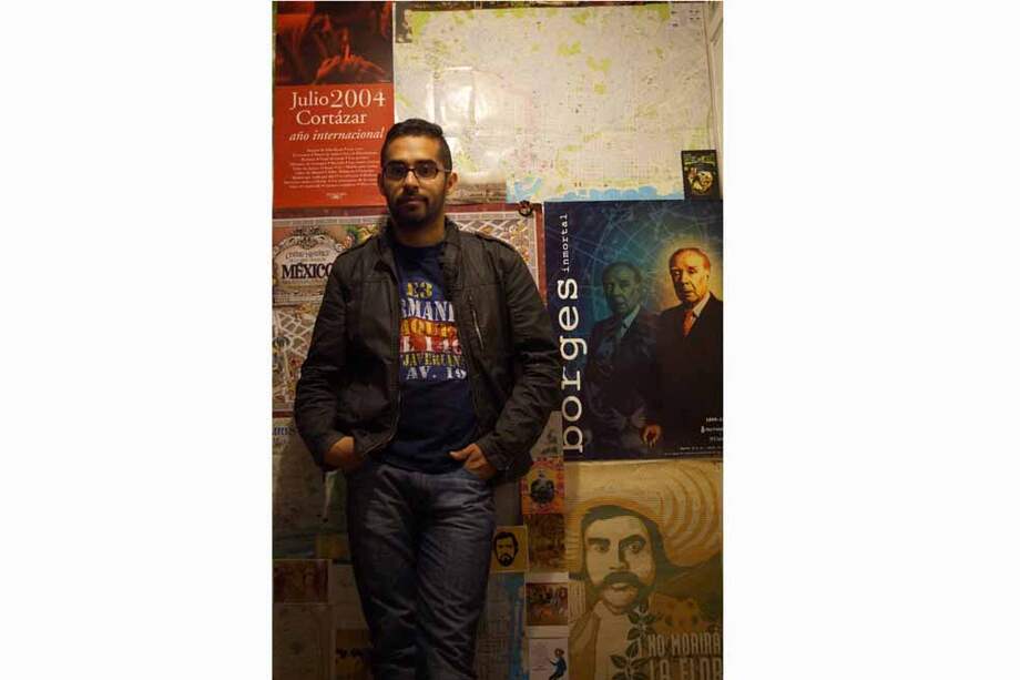 Juan Camilo Rincón desde el lugar que le sirve de inspiración: su casa. Al fondo, imágenes de sus autores preferidos. / Cortesía