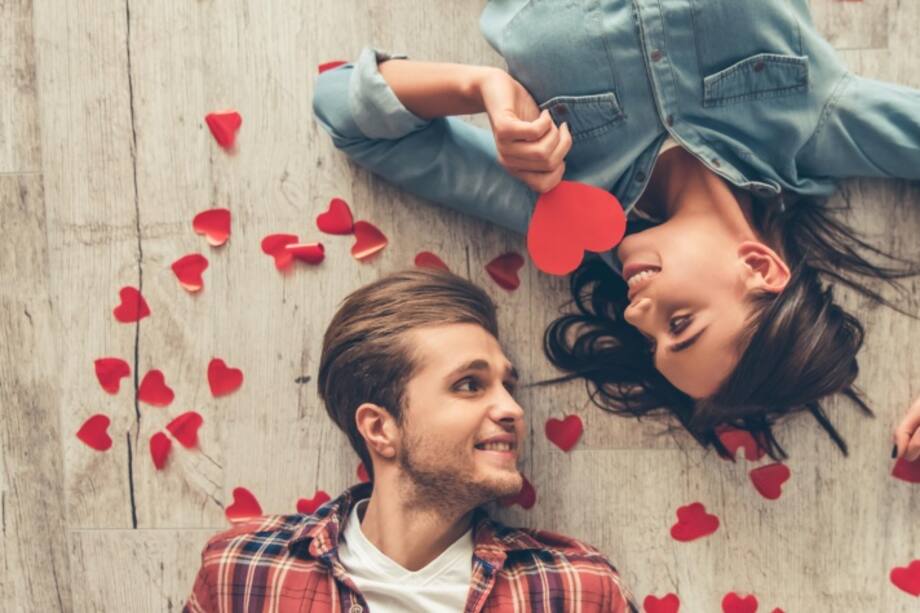 Pareja acostada en el piso llena de corazones