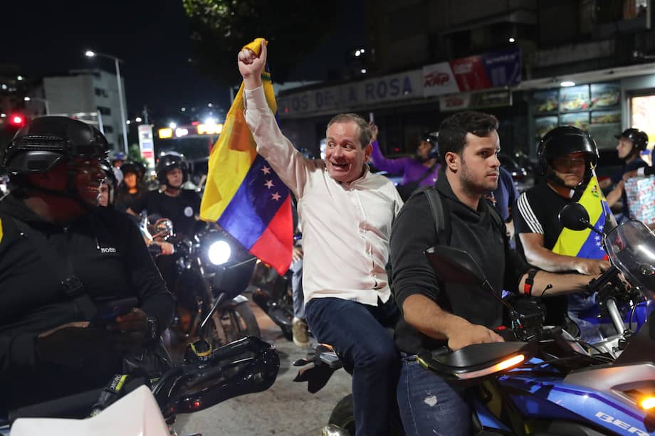 El opositor Juan Pablo Guanipa (c) sostiene una bandera de Venezuela en una manifestación este domingo, en Caracas (Venezuela), luego de su efímera liberación.