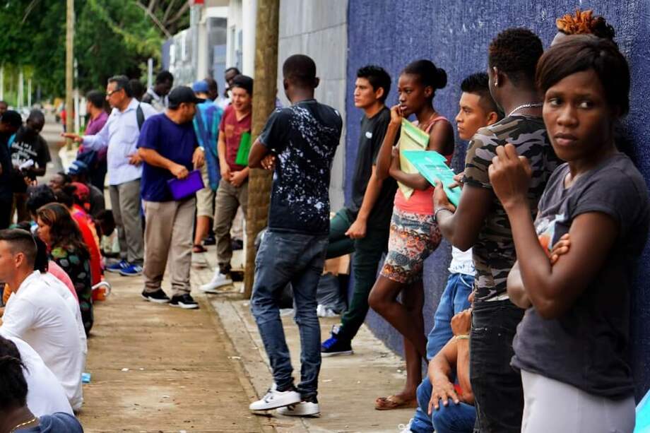 Migrantes provenientes de distintos países esperan para acceder a una estación migratoria y gestionar los documentos que les permita transitar por México. / EFE