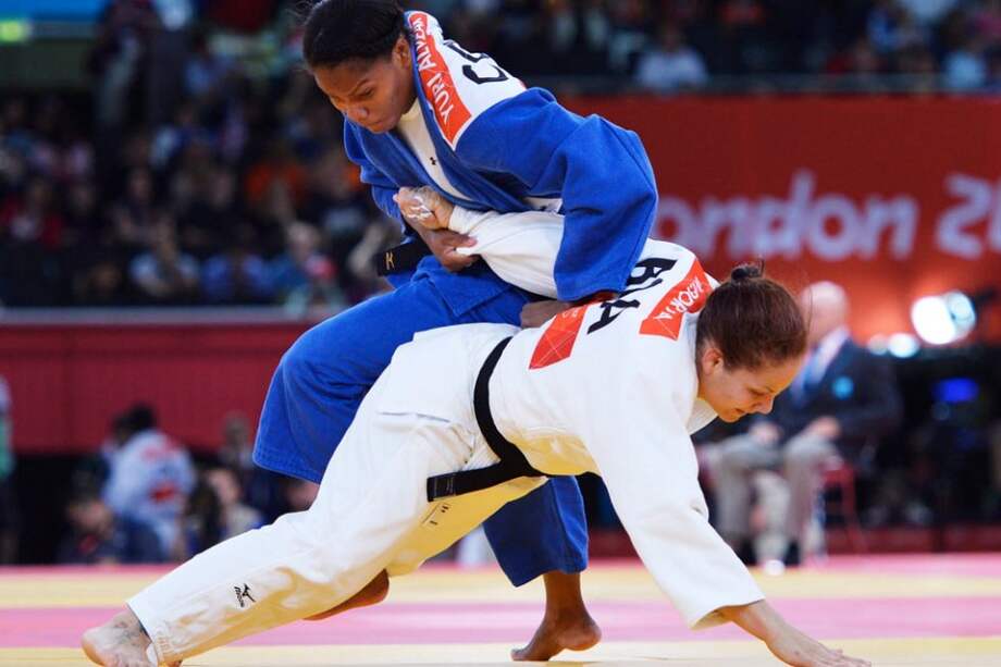 Yuri Alvear (de azul) lucha con la brasileña Maria Portela (de blanco) en octavos de la categoría de -70kg femenino. Foto: EFE