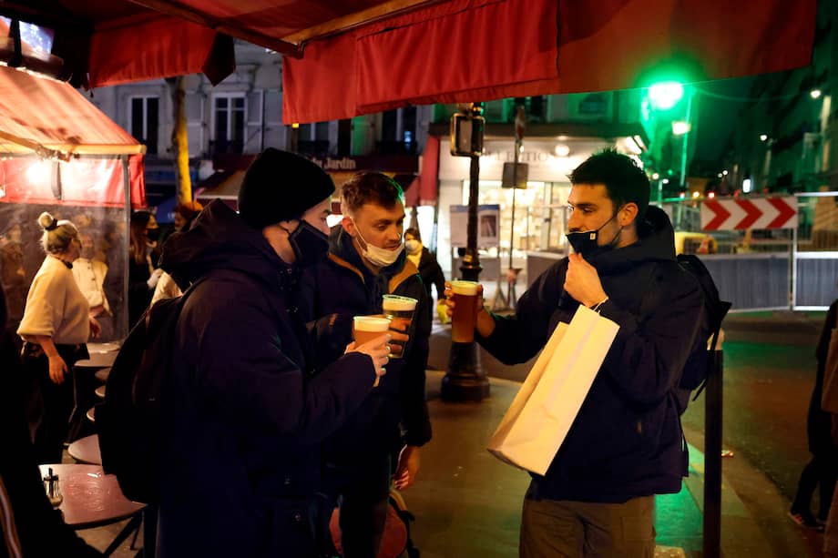 Jóvenes toman bebidas afuera de un bar en París el 15 de enero de 2021.
