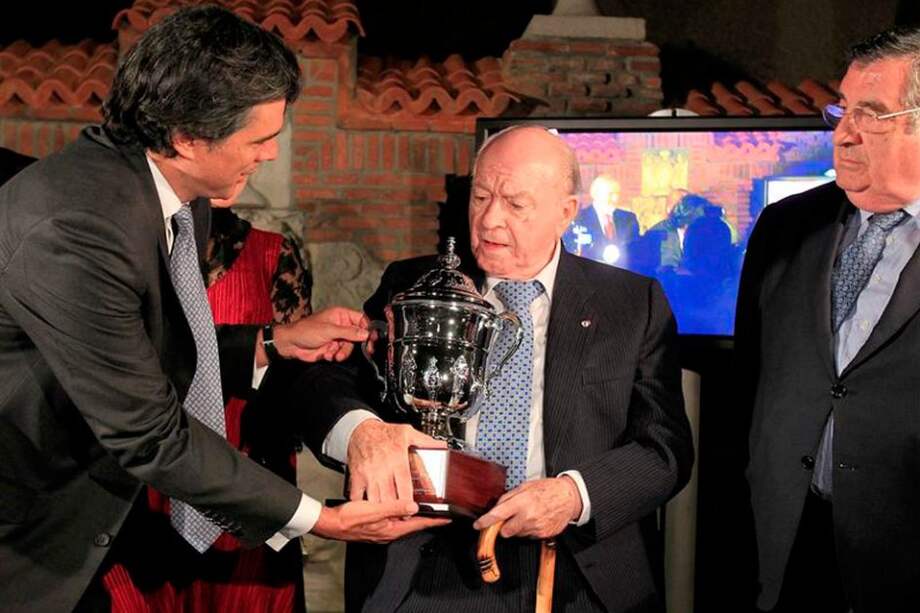 El presidente del Millonarios, Felipe Gaitán (i) entrega un trofeo conmemorativo al exfutbolista argentino Alfredo Di Stefano (c), presidente de honor del Real Madrid. / EFE