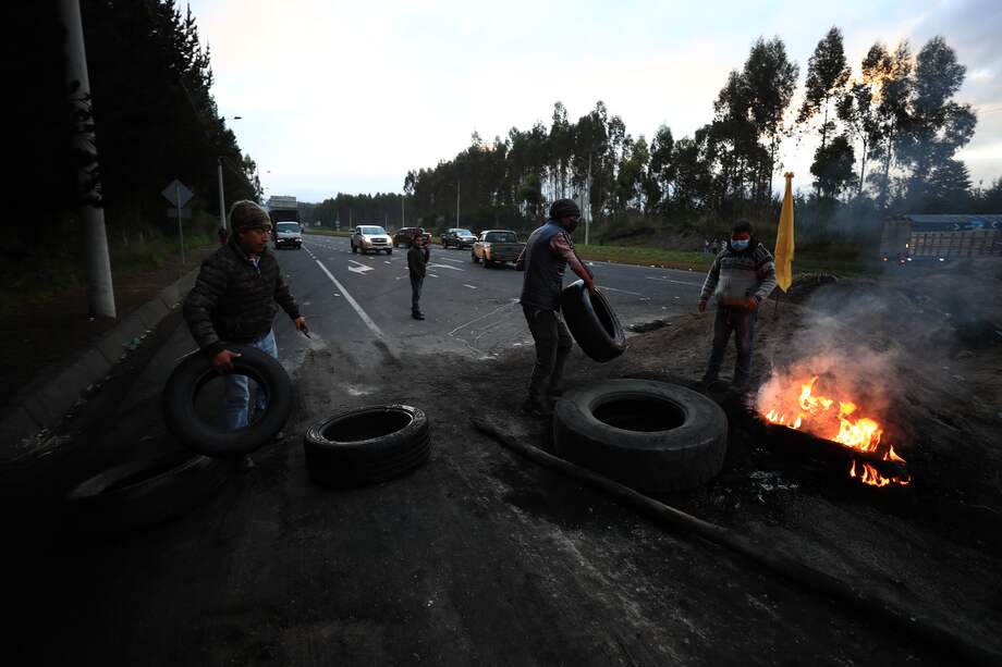 Indígenas montan una barricada para bloquear una vía durante una jornada de protestas, hoy, en el sector de la panamericana sur, en Chasqui, provincia de Cotopaxi (Ecuador).