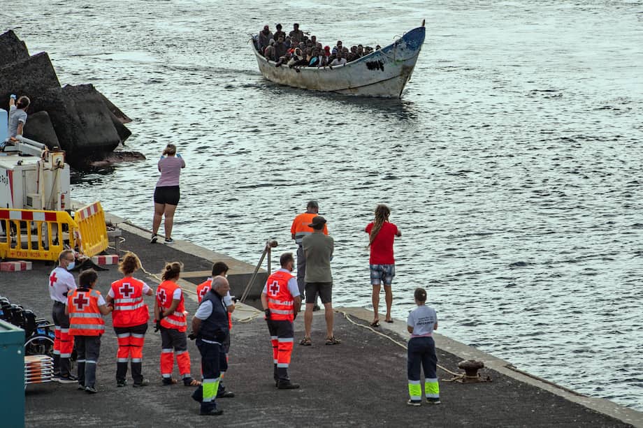 Miembros de la Cruz Roja Española observan la llegada de una embarcación tipo "cayuco" con 54 migrantes a bordo al puerto de La Restinga, en la isla canaria de El Hierro, el 15 de septiembre de 2024.