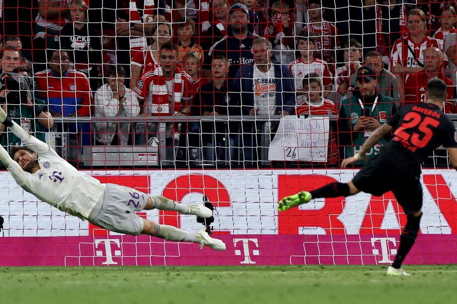 Exequiel Palacios (R) de Leverkusen convierte un penalti para marcar el gol del empate 2-2 durante el partido de fútbol de la Bundesliga alemana entre el FC Bayern Munich y el Bayer 04 Leverkusen en Munich, Alemania, el 15 de septiembre de 2023.