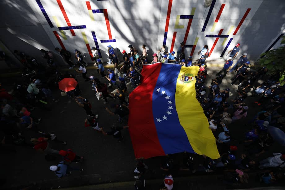 Los partidarios del presidente Nicolás Maduro exhiben una bandera venezolana durante una marcha para defender la supuesta victoria en las elecciones presidenciales en Caracas el 17 de agosto de 2024.
