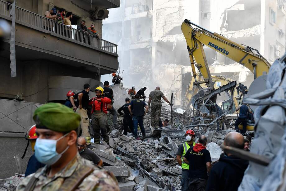 Equipos de rescate, utilizando excavadoras (parte trasera), buscan personas desaparecidas bajo los escombros de un edificio destruido después de que los ataques aéreos israelíes golpearan una zona residencial en el barrio de Basta, en el centro de Beirut, Líbano, el 23 de noviembre de 2024.