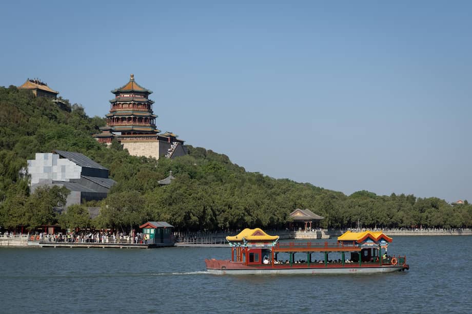 Un barco con turistas pasa junto a una pagoda en el Palacio de Verano de Pekín, China.