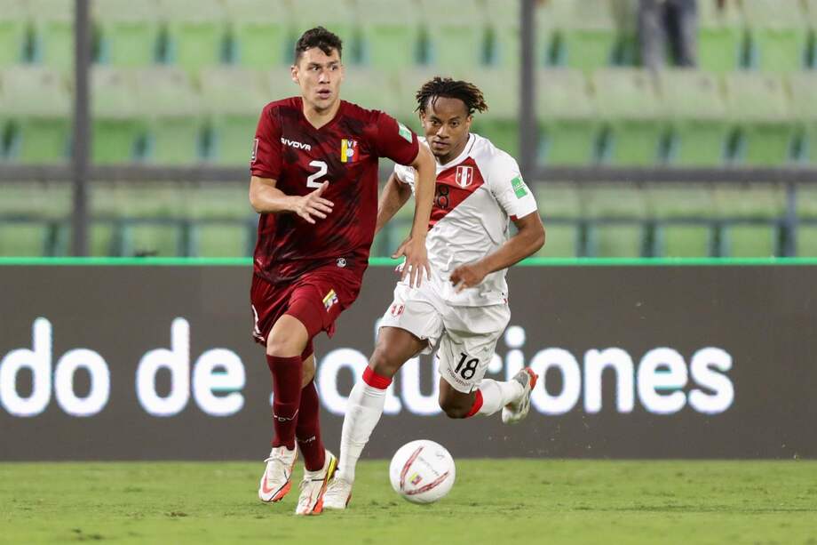 Nahuel Ferraresi, de Venezuela, disputa el balón con Andre Carrillo, jugador de Perú.