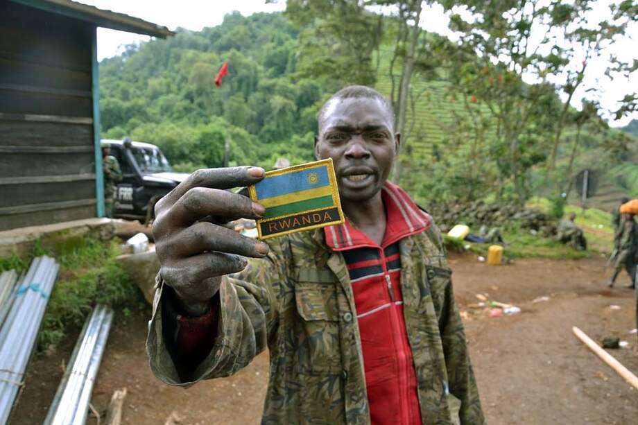 Un soldado del ejército congolés sostiene un parche con la bandera de Ruanda, encontrado en un campamento cerca a la ciudad de Goma, uno de los fortines del M-23. / AFP