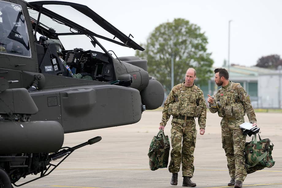 El príncipe de Gales, Guillermo (izq.). se prepara para abordar un helicóptero Apache en el Centro de Aviación del Ejército en Middle Wallop, Inglaterra, el lunes 13 de mayo de 2024.
