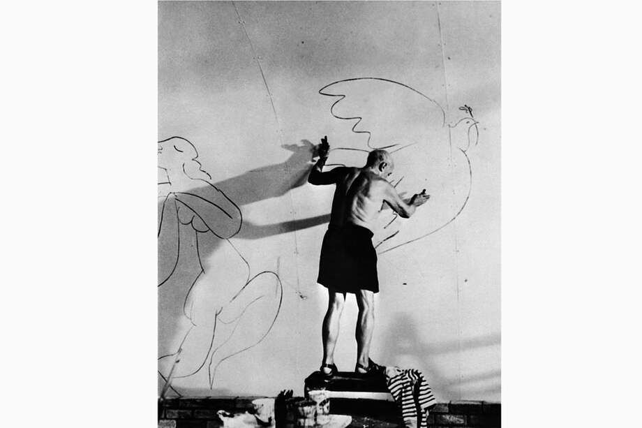 Picasso mientras pintaba una paloma en un muro de su casa en Mugins (Francia) en 1955. / AFP