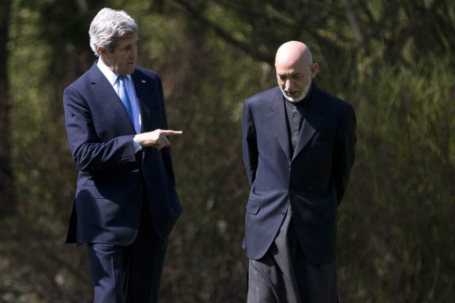 El secretario de Estado de EE.UU., John Kerry, conversa con Hamid Karzai, presidente de Afganistán. / AFP