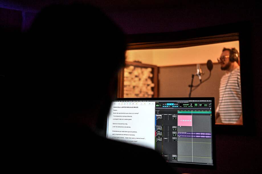 El locutor colombiano Daniel Soler de la Prada habla durante una sesión de grabación en un estudio en Bogotá el 18 de mayo de 2023. Locutores comerciales, actores de doblaje y narradores de audiolibros y videojuegos temen que su talento sea desplazado por voces sintéticas y que pierdan su sustento. Peor aún, pueden estar alimentando sin saberlo un dispositivo que les quitará el control de sus voces. (Foto por Juan BARRETO / AFP)