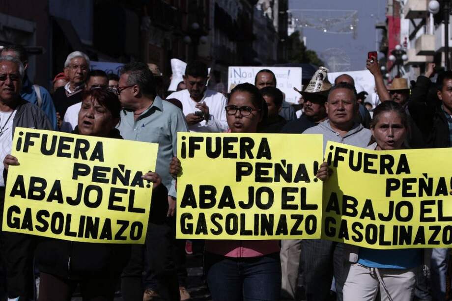 Miles de personas marchan en Puebla para protestar por el aumento del 20% en el precio de la gasolina. / AFP