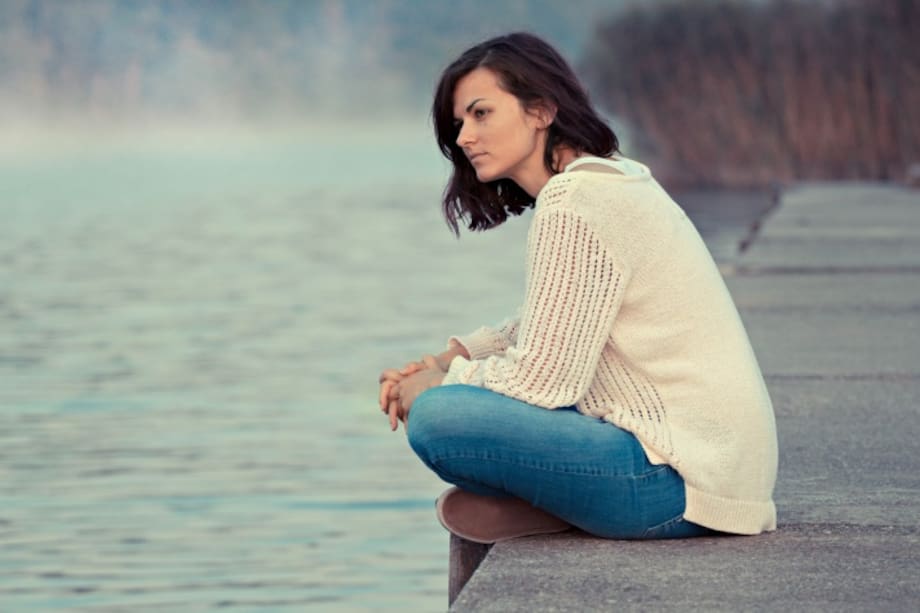 Mujer sentada al lado de la playa