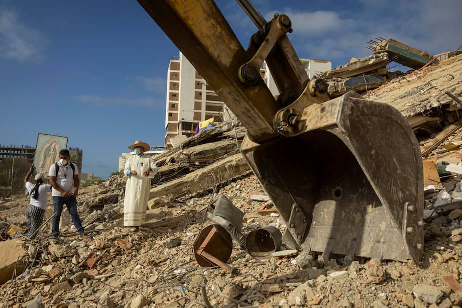 Un sacerdote acompaña con sus oraciones a familiares, voluntarios y rescatistas que continúan las labores de recuperación de cuerpos atrapados bajo los escombros tras los terremotos del pasado 24 de junio en Venezuela.
