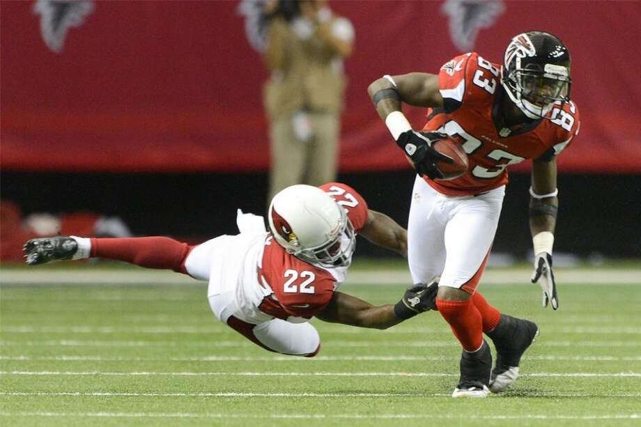 Harry Douglas escapa a una tacleada de un jugador de Arizona / AFP