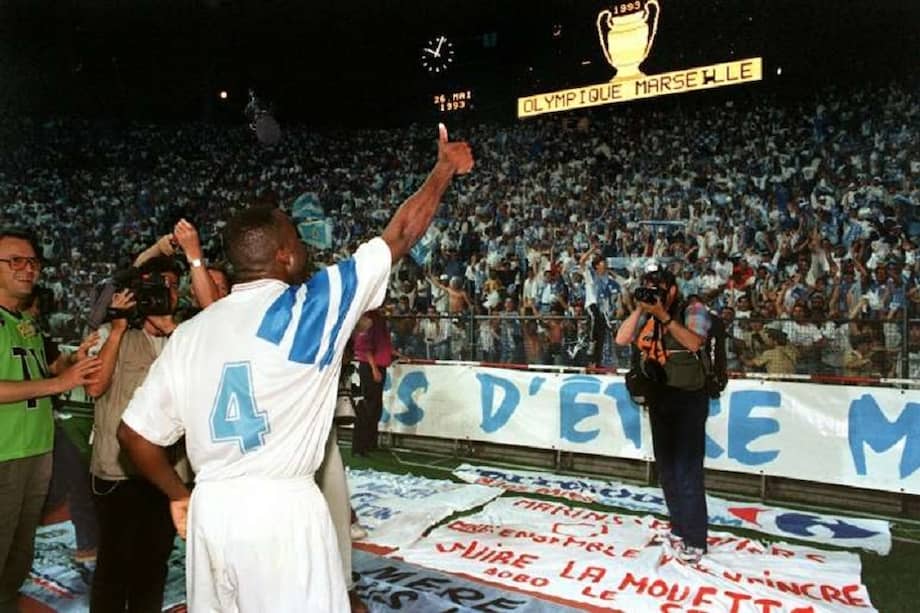 El defensor francés Éric Di Meco (izquierda) celebra con los aficionados del Marsella tras obtener el título continental.