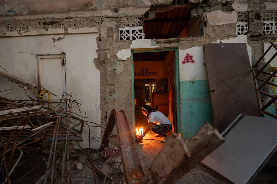 Una persona enciende velas durante un homenaje a las victimas por los terremotos