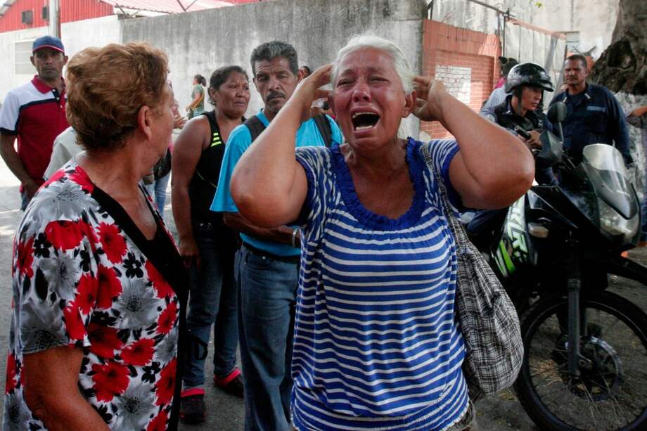 Familiares de reclusos de la prisión de Carabobo buscan información tras el motín e incendio que dejaron 68 muertos. / AFP
