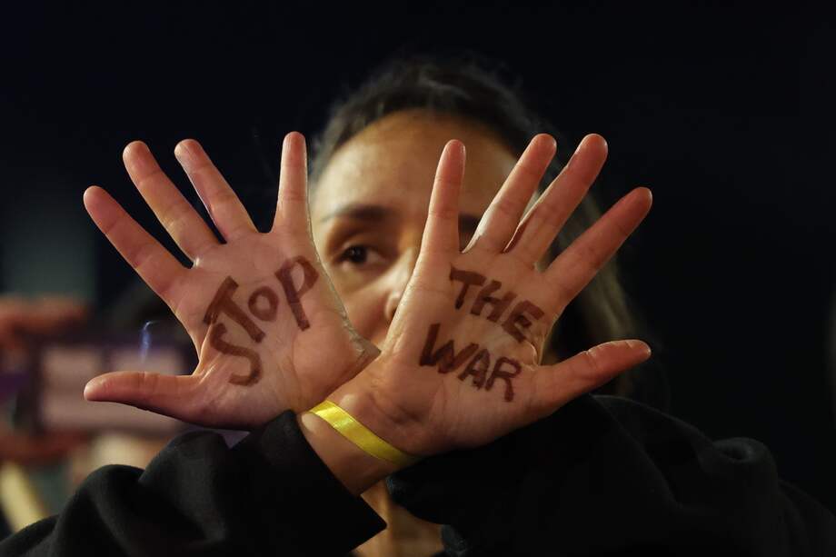 Una persona muestra sus manos con el lema "Detengan la guerra" ante familiares de rehenes israelíes retenidos por Hamás en Gaza
