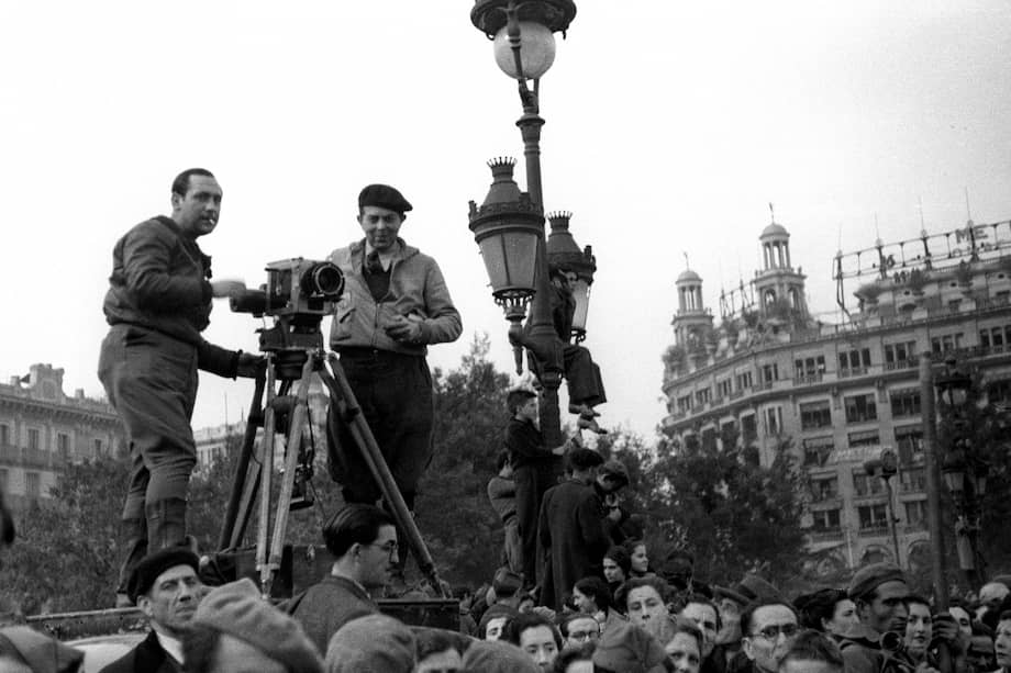 Barcelona, 27-1-1939.- Las tropas nacionales han entrado en la ciudad. Dos camarógrafos captan las imágenes de los soldados desfilando.