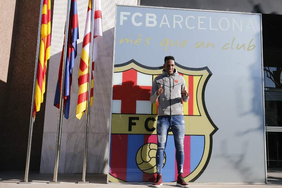 Yerry Mina en la tradicional foto con el escudo del Barcelona, en las oficinas del club. / AFP