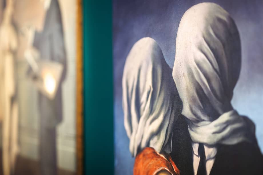 Los amantes, de René Magritte, convirtió un beso en una imagen inquietante: dos cuerpos están cerca, pero sus rostros cubiertos impiden el encuentro completo.