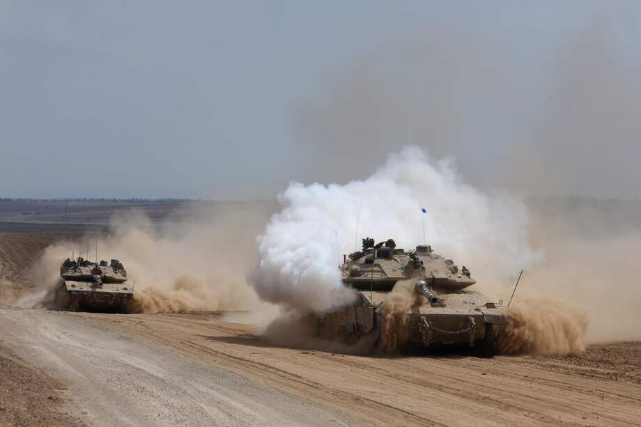 Los vehículos blindados de combate israelíes se dirigen hacia el norte de la Franja de Gaza, como se ve desde la frontera con Gaza en el sur de Israel