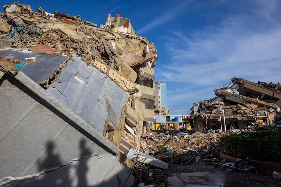 Rescatistas de Vietnam caminan sobre los escombros de las edificaciones destruidas en Catia La Mar, La Guaira (Venezuela).
