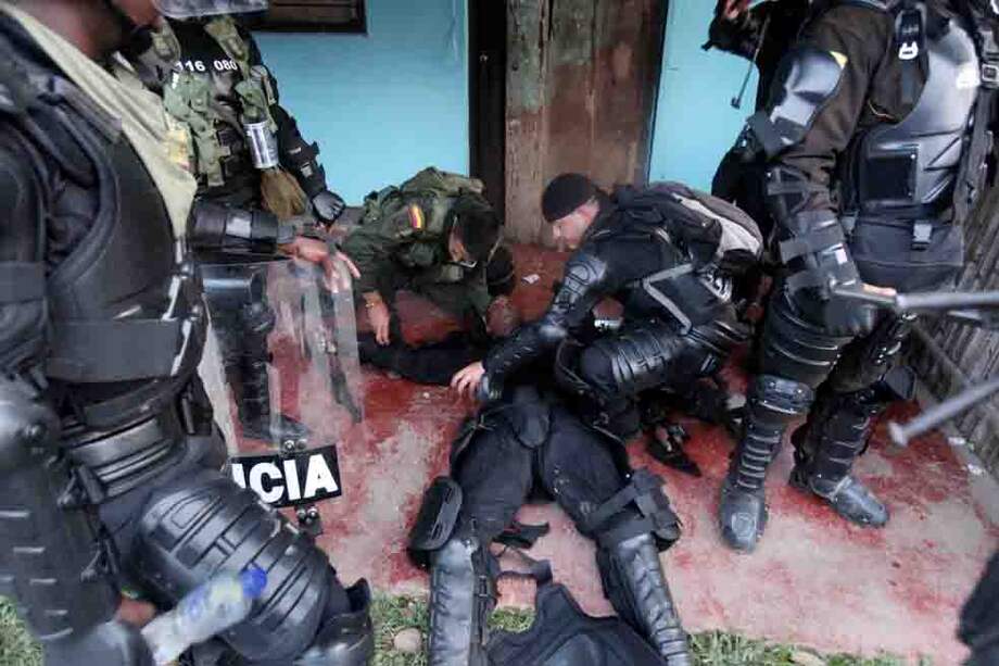 Miembros del Esmad atienden a un compañero afectado durante la explosión de un artefacto artesanal,en medio de un choque con los indígenas en el Cauca. / EFE