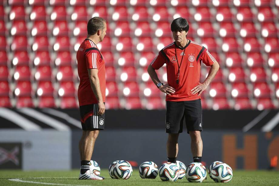 El entrenador alemán Joachim Löw (centro) habla con su asistente, Hansi Flick. / EFE