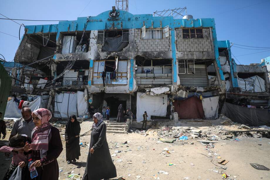 Palestinos desplazados internos caminan junto a una clínica de la ONU destruida tras un ataque aéreo israelí en el campamento de refugiados de Jabalia, al norte de la Franja de Gaza, el 2 de abril de 2025.