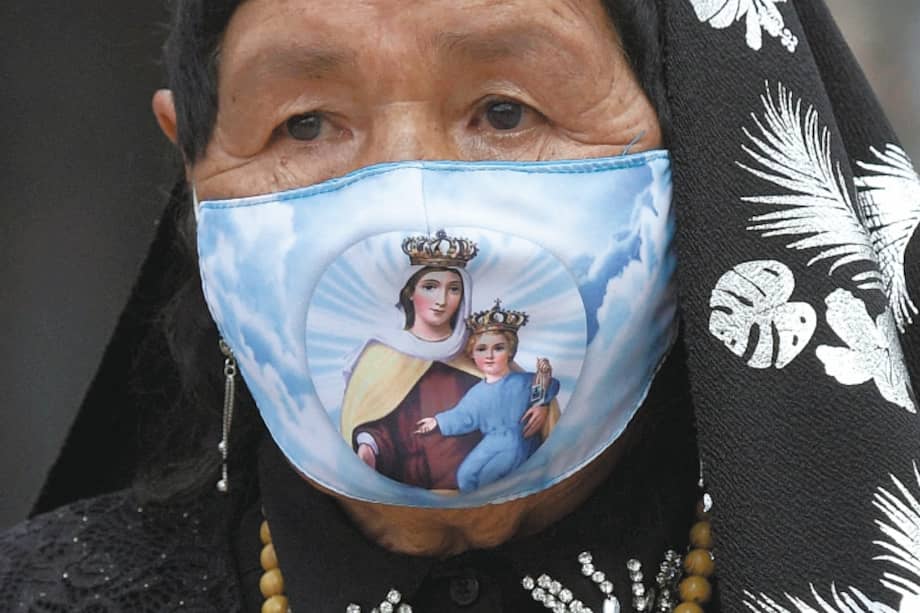 A Catholic devotee wearing a face mask as a precautionary measure against the spread of the novel coronavirus disease, COVID-19, attends a Holy Week celebration on Good Friday, at Bolivar square in Bogota on April 2, 2021.
/ AFP / Raul ARBOLEDA