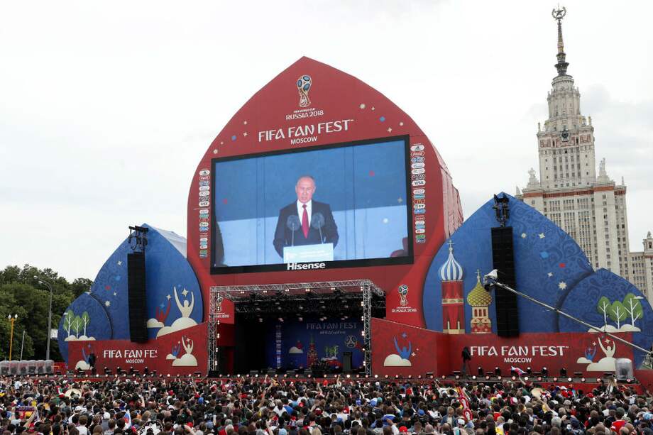 El presidente de la Federación Rusa, Vladimir Putin, es oído en Moscú donde se congregan aficionados al fútbol para el "fan-fest" del Mundial 2018. /AFP