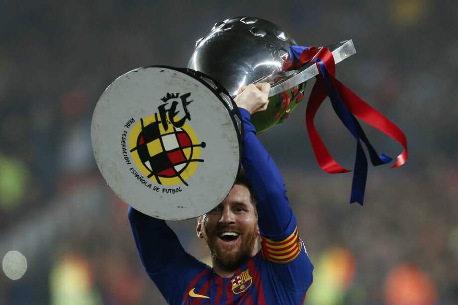 Lionel Andrés Messi Cuccittini levanta el trofeo liguero del Fútbol Club Barcelona. / AFP