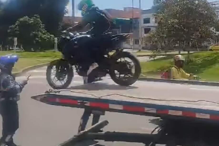 Momento exacto en el que el motociclista salta de la grúa para impedir la inmovilización de su vehículo.
