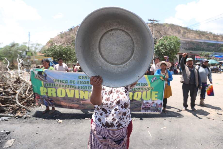 Una seguidora del expresidente de Bolivia, Evo Morales, golpea un tazón metálico en una marcha este martes, por una vía bloqueada en Parotani (Bolivia).