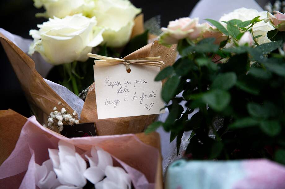 Ramos de flores con un mensaje escrito a mano que dice "Descansa en paz Lola, valentía para la familia", a las afueras del lugar donde residía la niña.