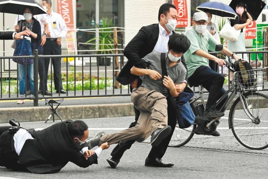 Esta imagen, obtenida del periódico Asahi Shimbun, muestra a un hombre (centro, der.), sospechoso de disparar al ex primer ministro japonés Shinzo Abe, siendo derribado al suelo por la policía en la estación Yamato Saidaiji de Nara el 8 de julio de 2022. Abe fue declarado muerto el 8 de julio, según confirmó el hospital que lo atendía, tras recibir un disparo en un acto de campaña en Nara.